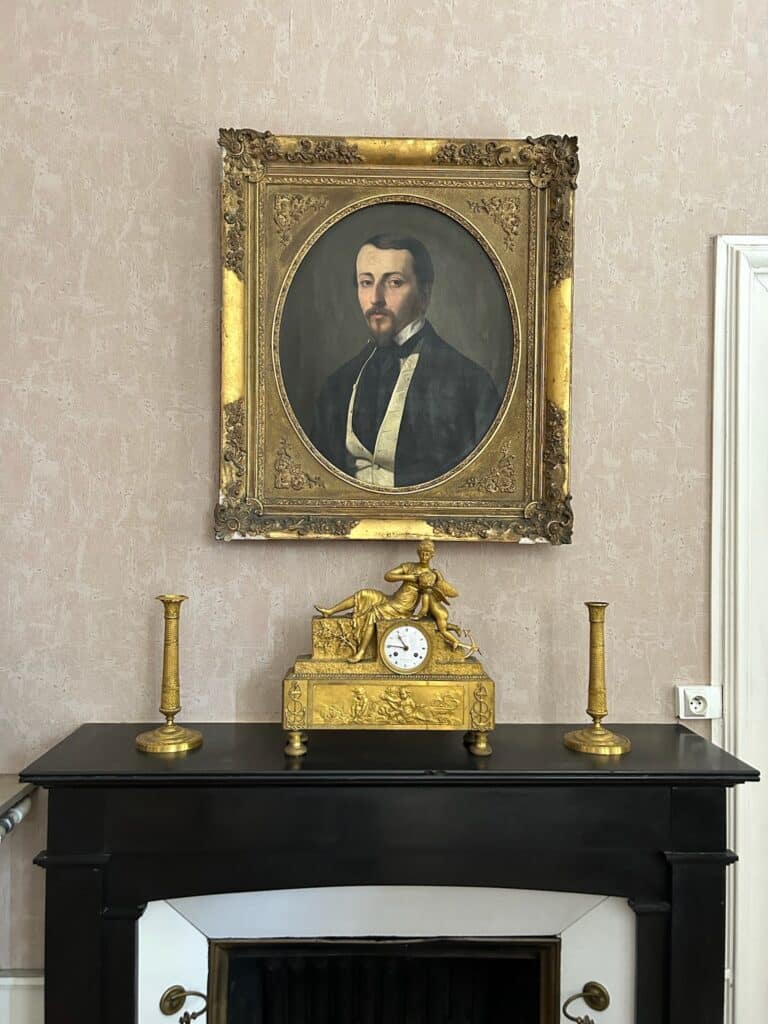 Portrait et pendule dorée sur une cheminée, collections de l'Académie
